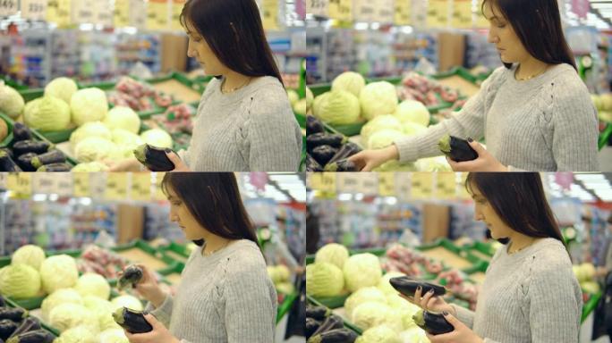 一家超市蔬菜部门的年轻女子选择茄子