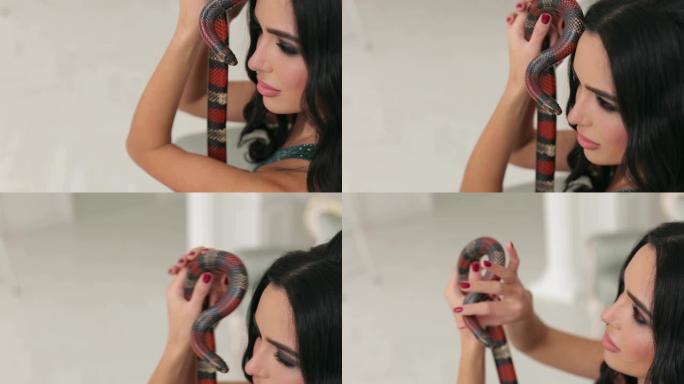 一个专业化妆的女孩的特写镜头手里拿着一条蛇。
