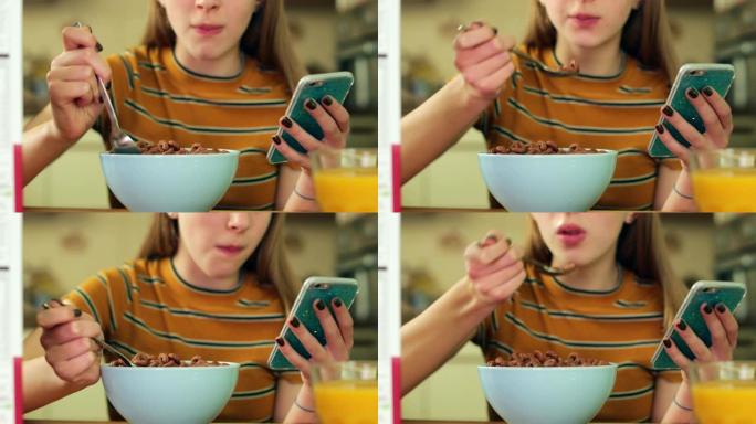 十几岁的女孩在手机上吃不健康的一碗含糖早餐麦片发短信