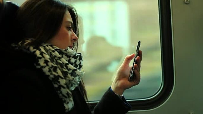 女人在火车通勤时看着她的手机技术设备