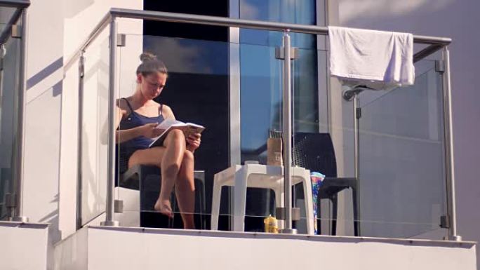 阳光明媚的天气，女人在阳台上看书。女孩在户外看书