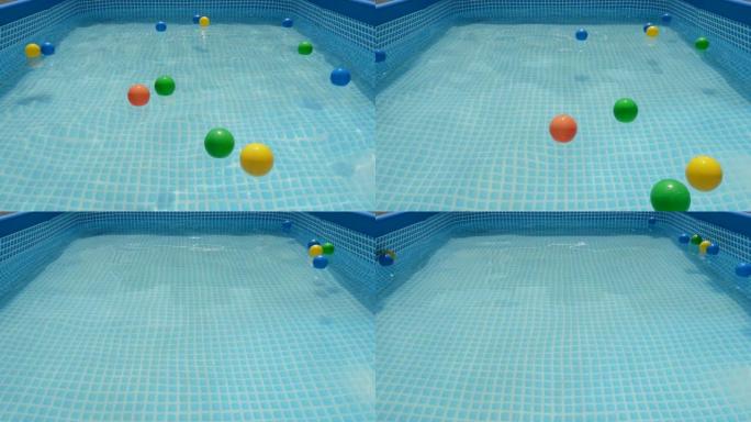 不同颜色的球漂浮在夏季小水池的水中