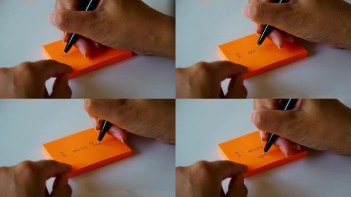 在橙色的贴纸或记事本上手写 “我想念你” 一词。4k素材