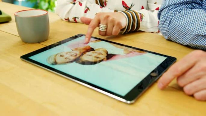夫妇在数字平板电脑上浏览家庭照片