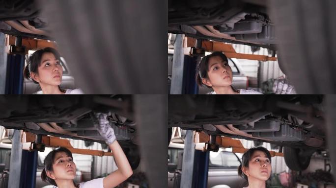 特写侧视图: 年轻女机械师检查车下的缺陷