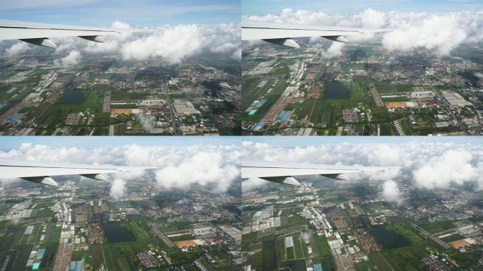 飞机飞过地球上方的云层，下面可以看到城市道路和屋顶