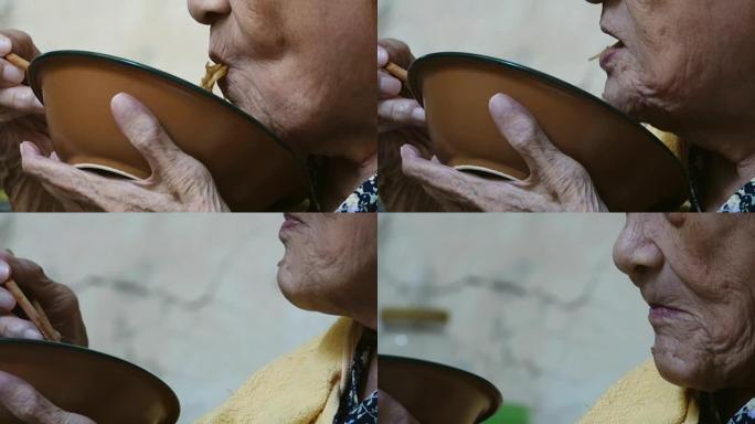 90岁以上健康的亚洲老妇吃午饭，侧视。