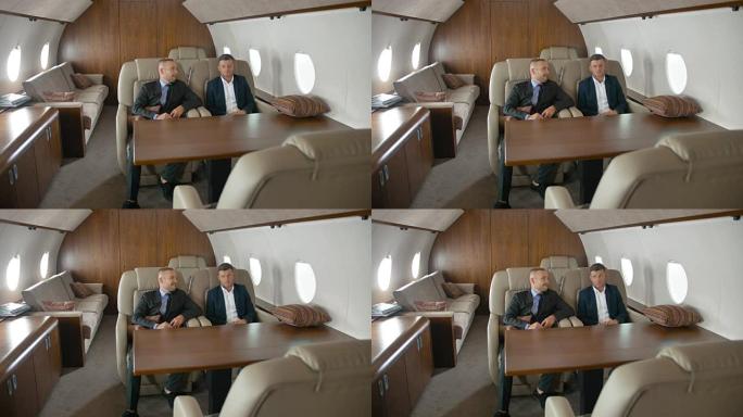 两个商人坐在私人飞机上聊天