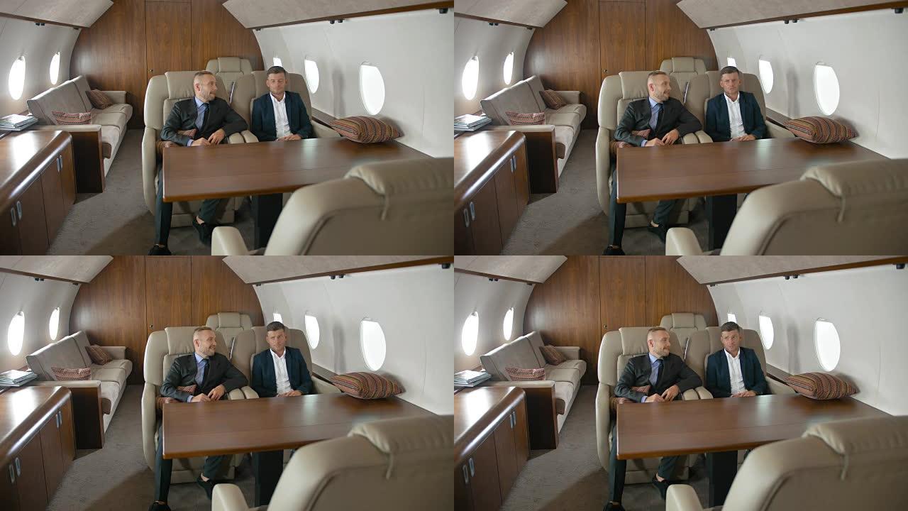 两个商人坐在私人飞机上聊天