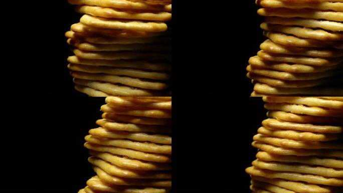 旋转的黑色背景上的方形饼干堆叠。饼干旋转。
从头顶视图旋转饼干