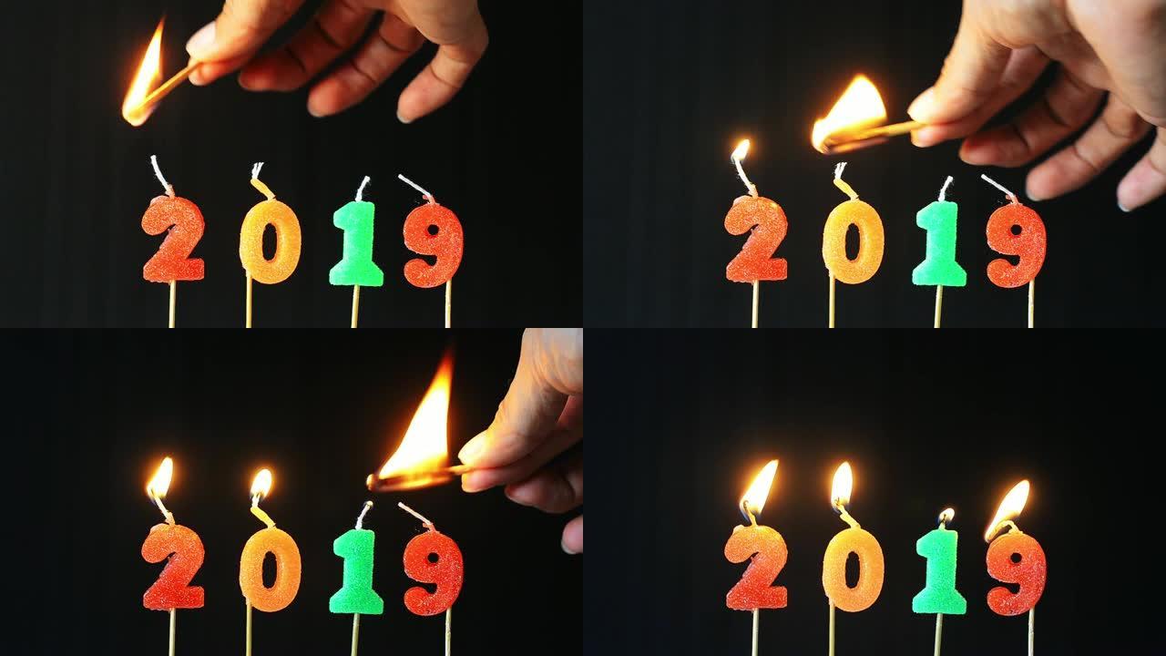 手手点燃蜡烛新年快乐2019用烟火七彩闪光蜡烛数字燃烧闪耀黑色背景倒计时从年底和庆祝日欢迎来到新年。
