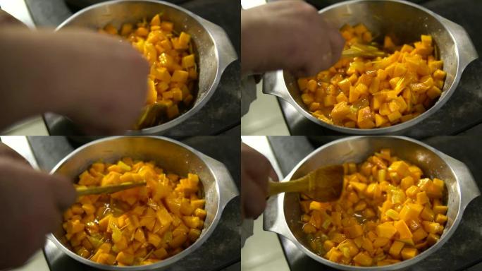 厨师准备了一个南瓜菜，用勺子将这些碎片混合在盘子里