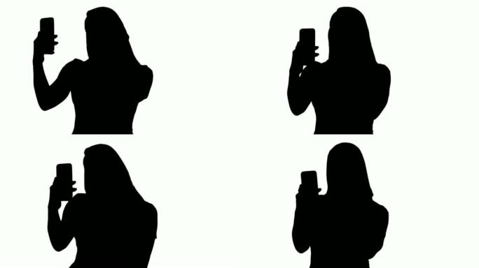 剪影快乐女人用手机自拍拍照