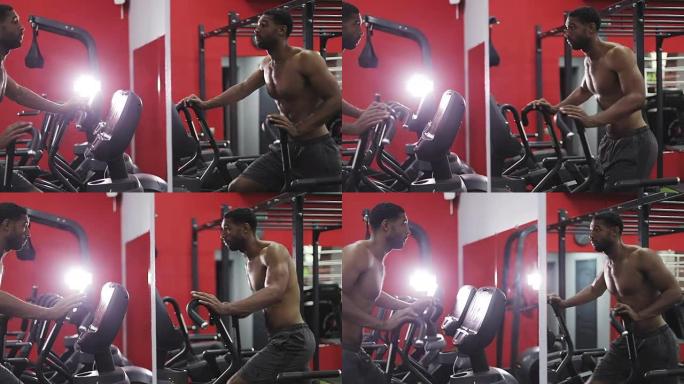 年轻的黑人男子在椭圆机锻炼。