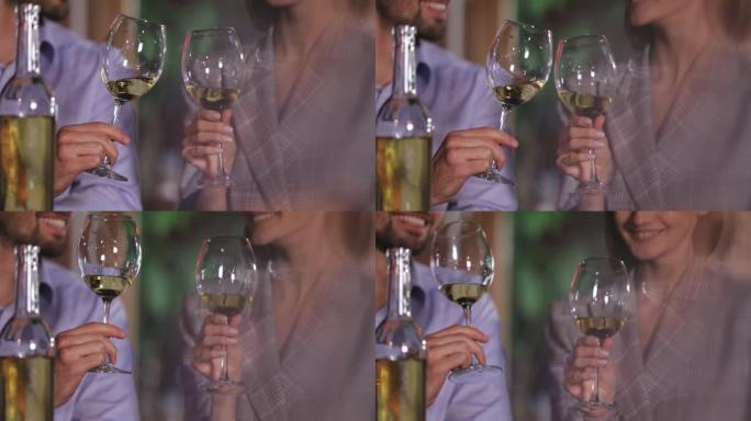 情侣在浪漫的晚餐上用白酒杯欢呼