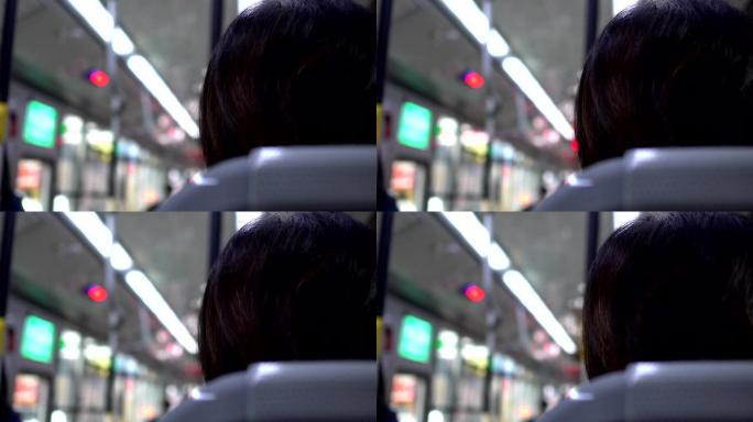 乘客的背部，在摇晃的公共汽车上。
