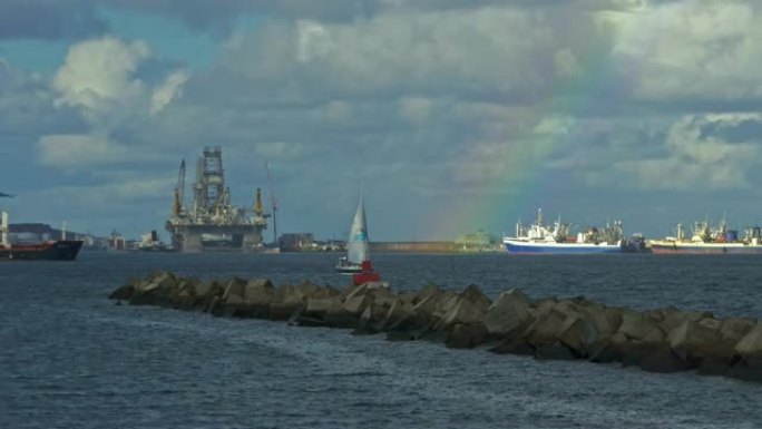 港口里有彩虹和破浪船的大船和小帆船