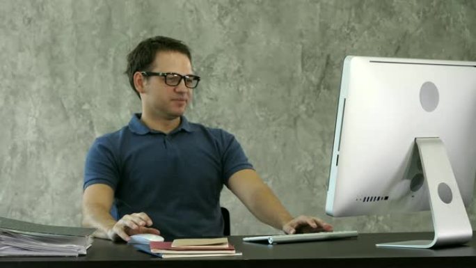 无聊的年轻人坐在电脑前的桌子上