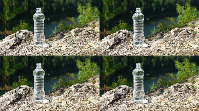 一瓶干净的水站在岩石上，在山区。健康与生态主题。高清慢动作x4