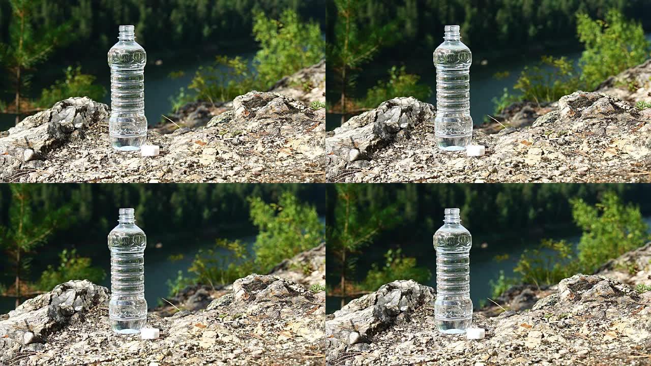 一瓶干净的水站在岩石上，在山区。健康与生态主题。高清慢动作x4