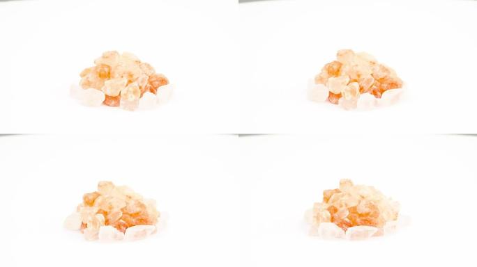 喜马拉雅粉色盐水晶堆。在转盘上旋转。孤立在白色背景上。特写。宏观。