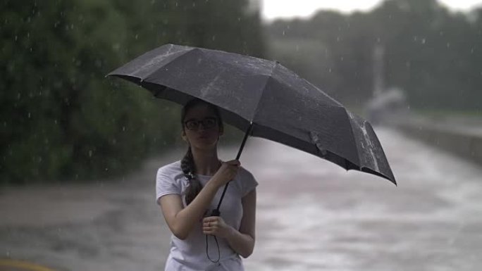 女孩在雨天旋转雨伞，看着雨滴打在雨伞上，秋天的心情，慢动作，户外
