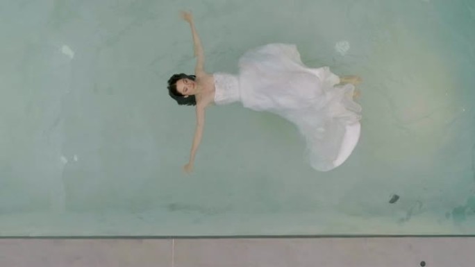 用婚纱漂浮在水中的女人的鸟瞰图，希腊。