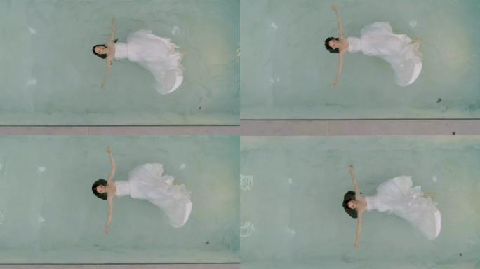 用婚纱漂浮在水中的女人的鸟瞰图，希腊。
