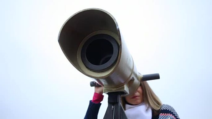 女人用双筒望远镜看。带电动滑块的全高清。