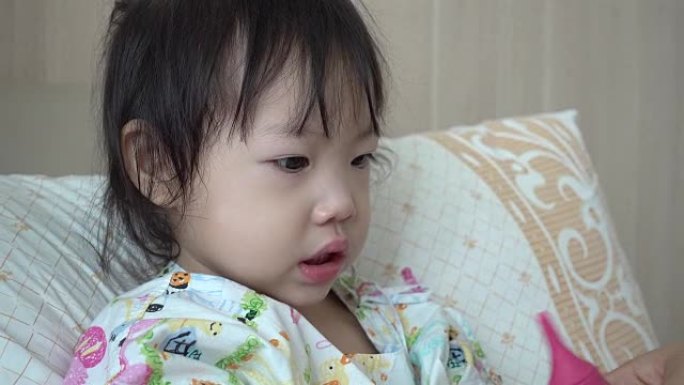 小女孩因流感病躺在医院的床上。