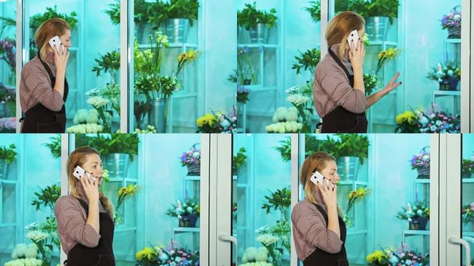 花店的老板在电话里聊天，看着鲜花的陈列柜。
