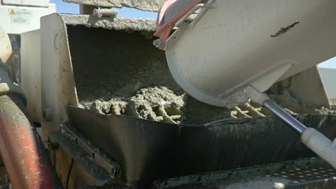 将混凝土水泥从卡车倒入泵中。