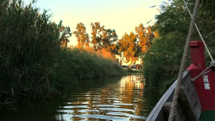 日落时在西班牙巴伦西亚的泻湖 “La Albufera” 航行