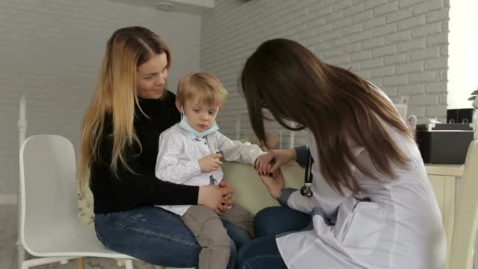 女医生牵着小男孩在医院照顾。