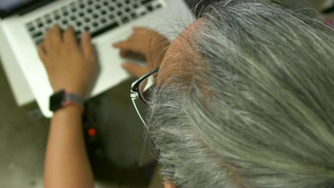 亚洲男子从事电脑笔记本电脑，小企业。