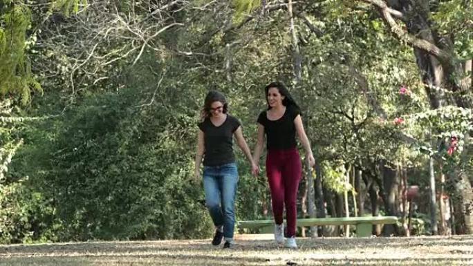 两个女朋友一起在公园散步，互相拥抱在一起笑