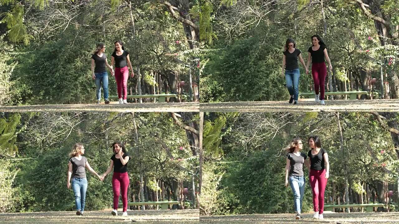 两个女朋友一起在公园散步，互相拥抱在一起笑