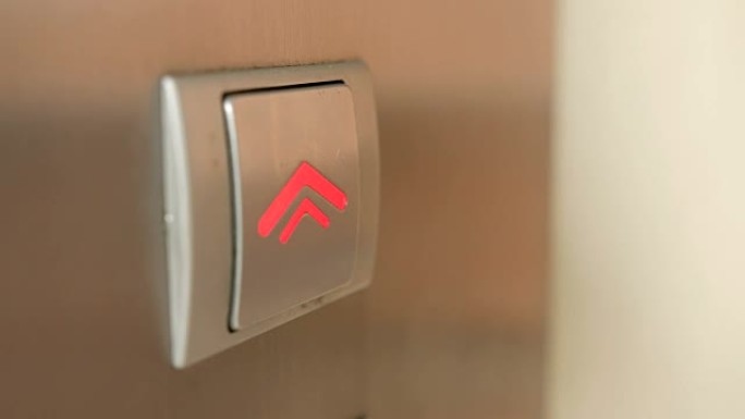 向上电梯按钮的极端特写，手指推动