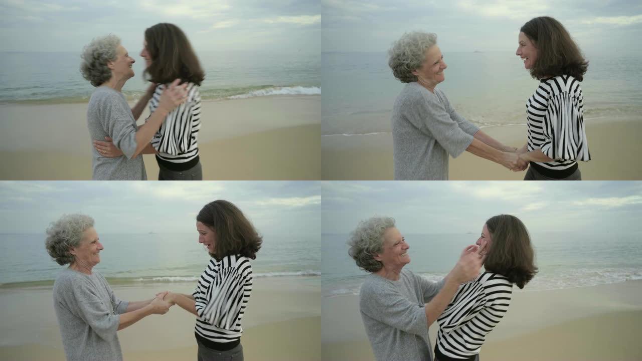 资深母亲与成年女儿在海边的海滩上拥抱