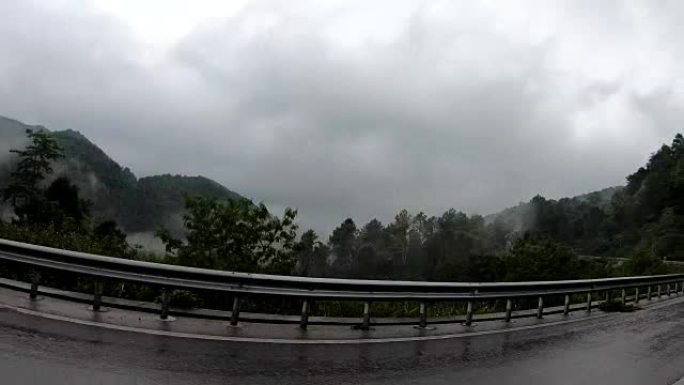 开车时，在路旁下雨后，看着窗外的山景。公路旅行假期