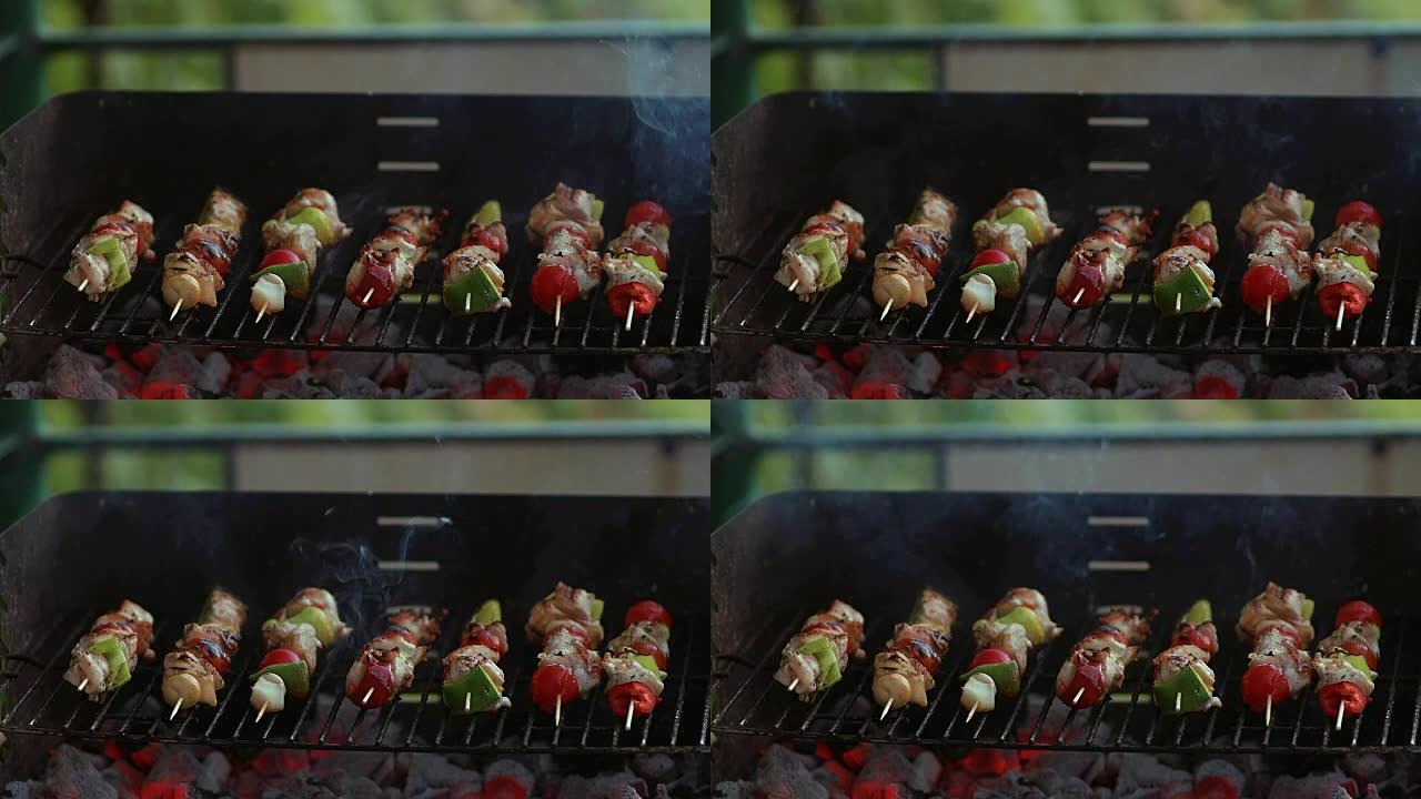慢动作在烧烤架上的竹签上烹饪新鲜蔬菜和腌制的肉，并带有火和吸烟特写
