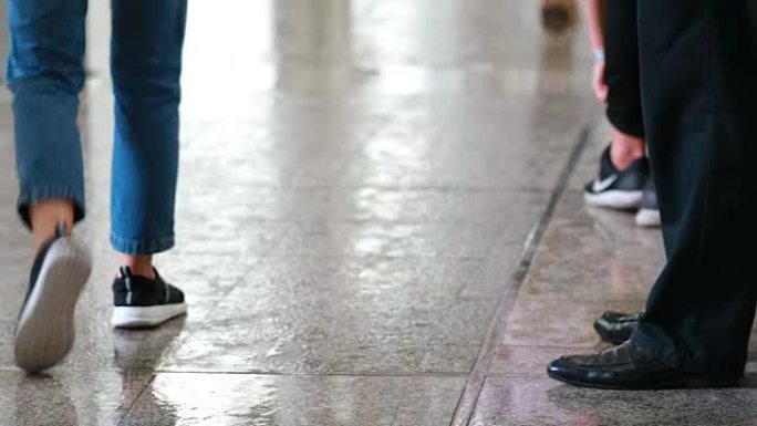 许多人在雨天穿着湿鞋在城市里下雨倒影
