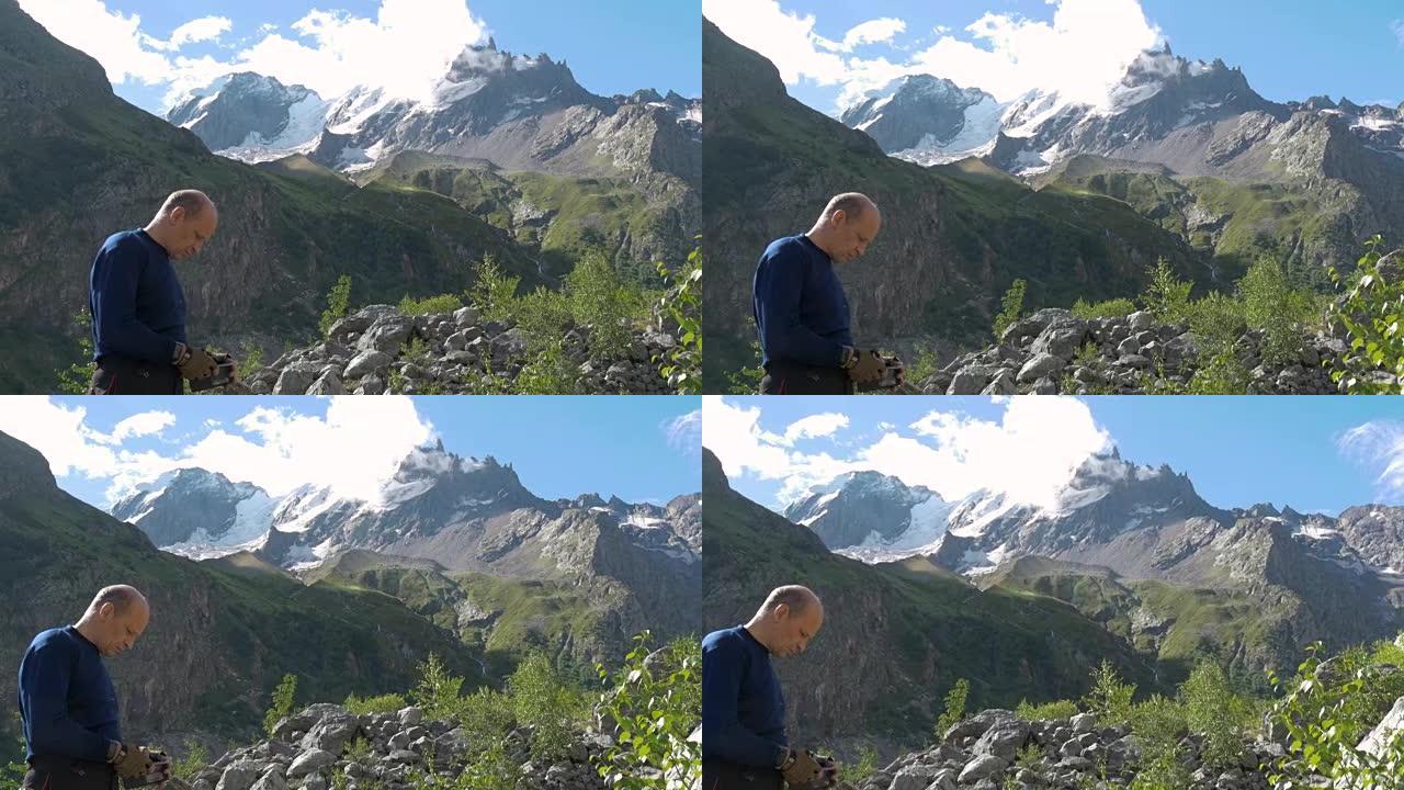 该名男子正对着山峰，看着智能手机。他选择了路线。