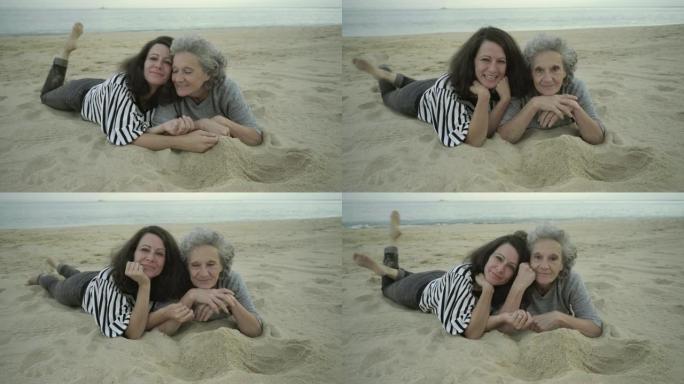 快乐的成年女性躺在沙滩上玩得开心