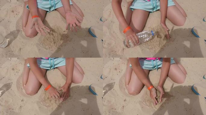 女孩的手在夏天的海滩上用沙子和水做沙球