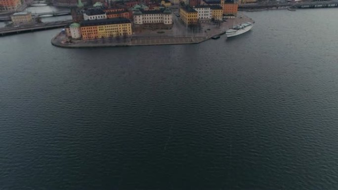 斯德哥尔摩市中心的鸟瞰图。无人机在水上飞行，相机在Riddarholmen岛上以及旧城区的建筑物和塔