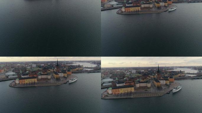 斯德哥尔摩市中心的鸟瞰图。无人机在水上飞行，相机在Riddarholmen岛上以及旧城区的建筑物和塔