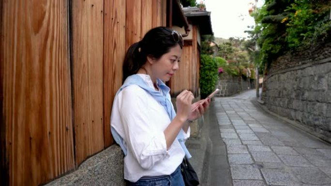美丽的女游客依靠木墙