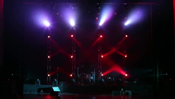 在舞台上的音乐会上交替闪烁红色和紫色聚光灯。