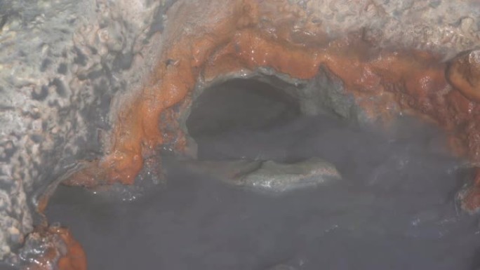 天然火山温泉从洞中溅出沸腾的矿泉水